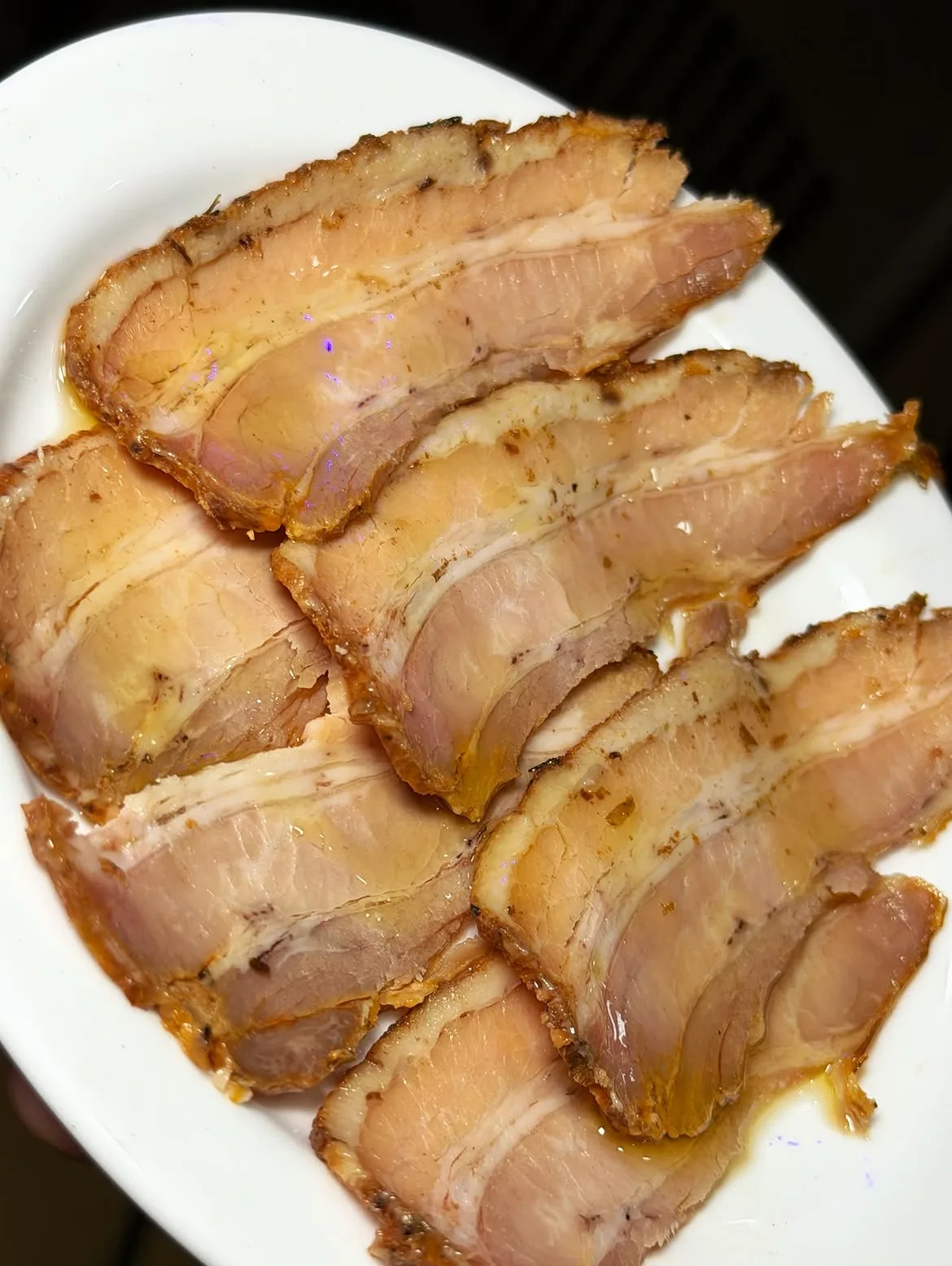 Chicharrones de la Sierra cortados en lonchas sobre plato blanco
